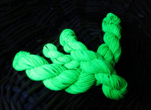 hand dyed uv reactive green sock yarn under black light