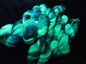 indie dyed uv mermaid green merino sock yarn under black light