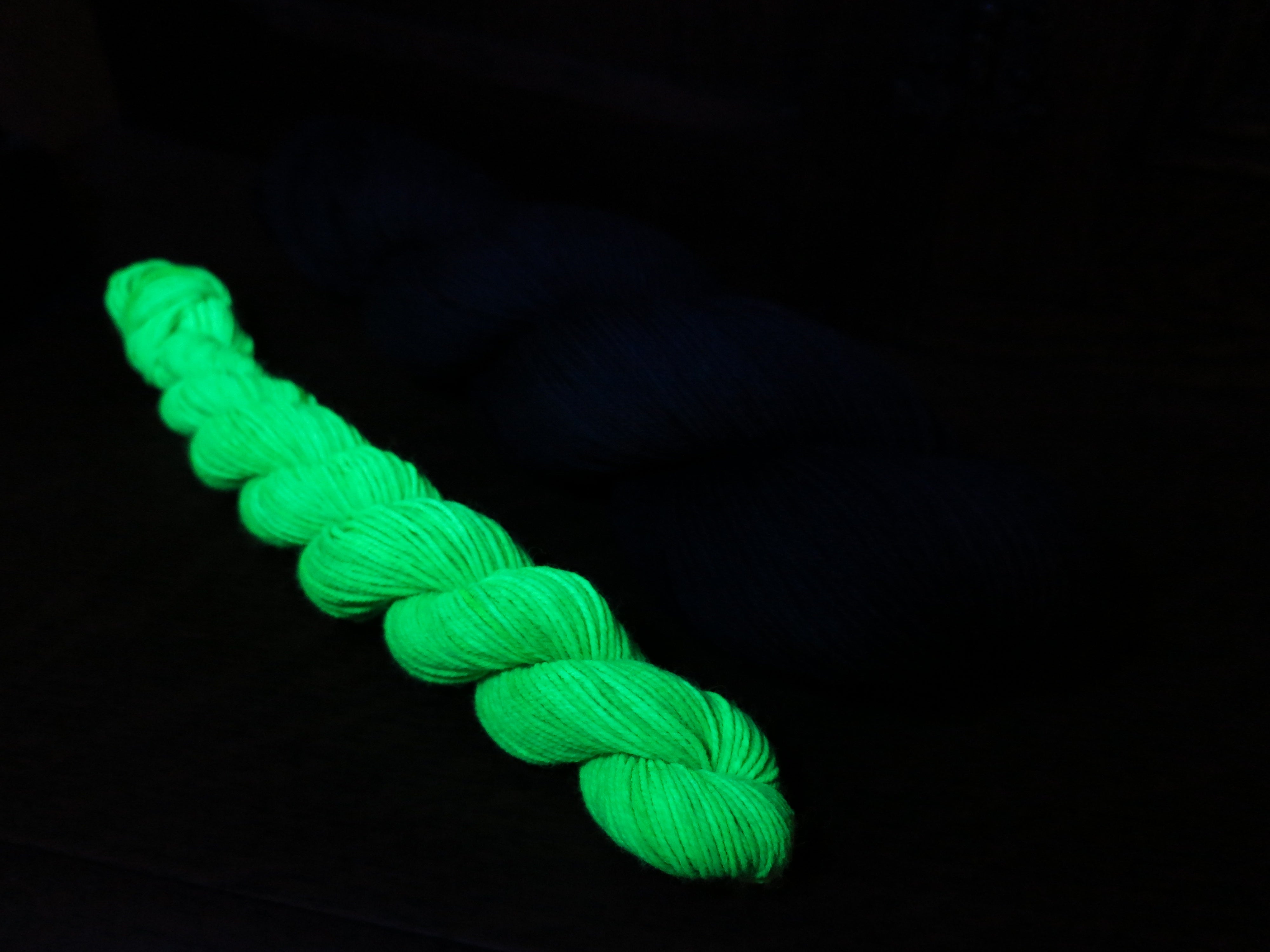 indie dyed black light responsive green sock yarn skein