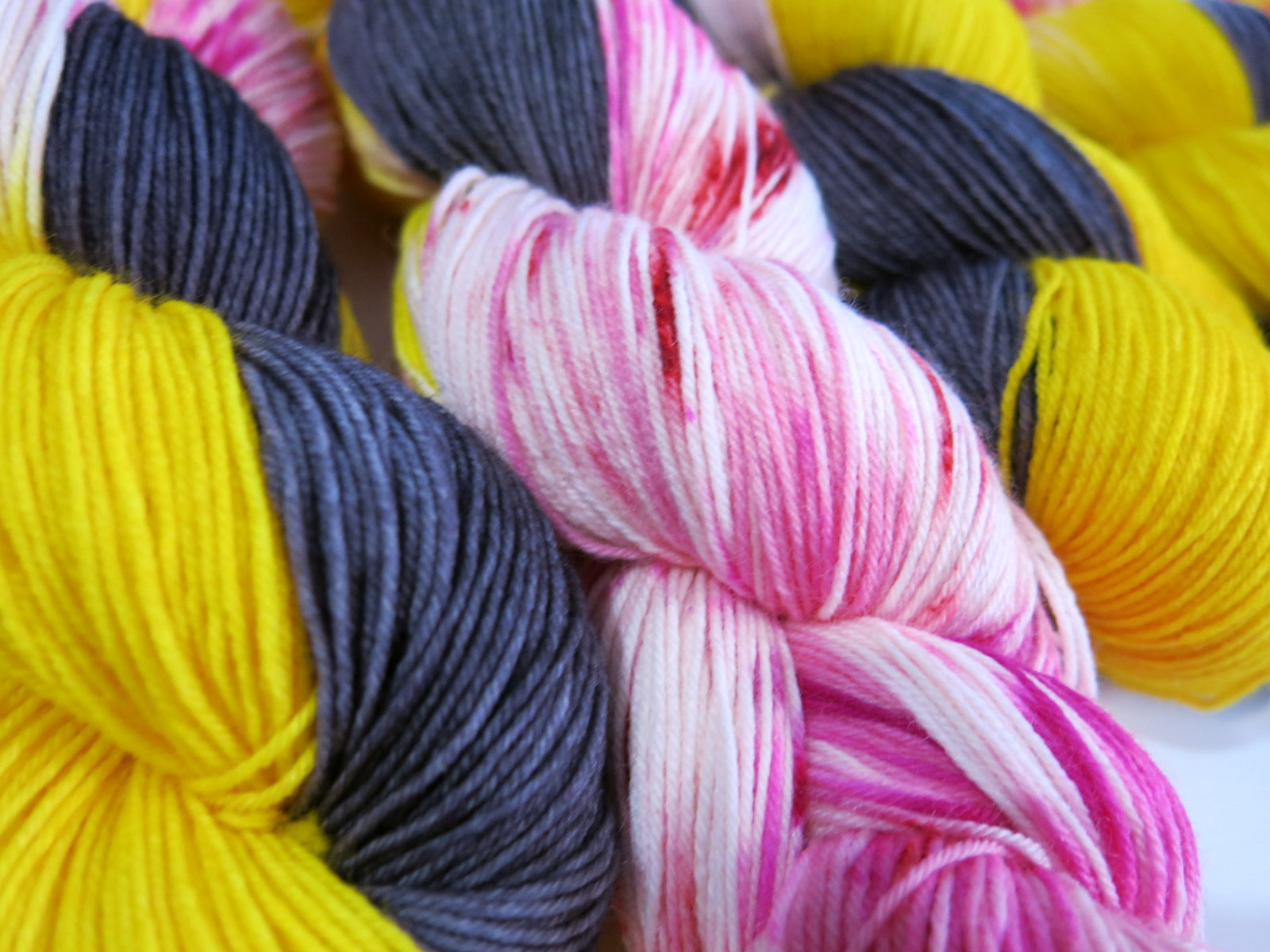 hand dyed yarn skeins with uv reactive yellow and pink