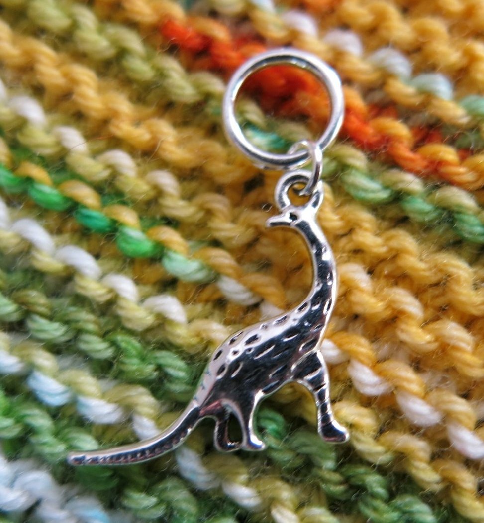 silver dinosaur charm on a snagless jumpring for knitting projects