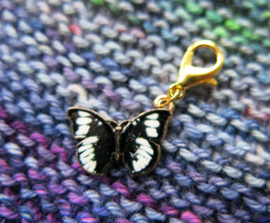 black and white enamel butterfly charm on a gold coloured lobster clasp