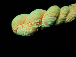 hand dyed neon orange yarn fluorescing under uv black light