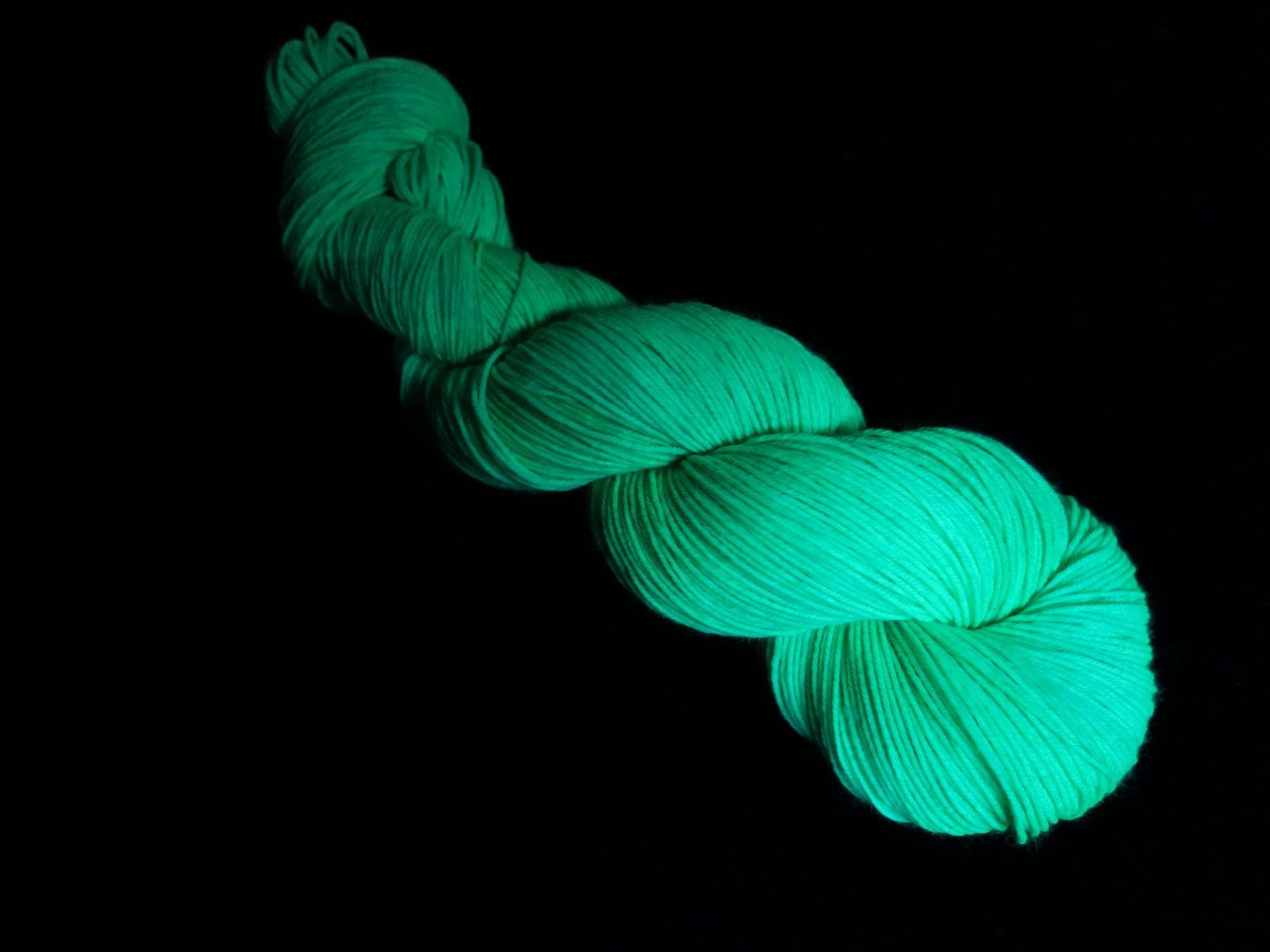 hand dyed green yarn fluorescing under uv black light