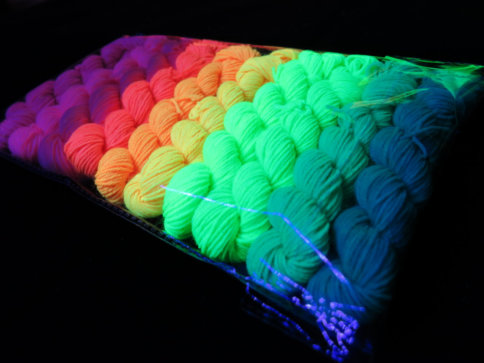 hand dyed uv reactive yarn mini skiens fluorescing under black light