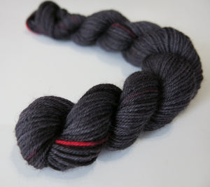 Black widow spider coloured black and red mini skein of yarn