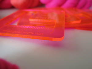 acrylic swatch rulers in neon pink orange viewed from the side