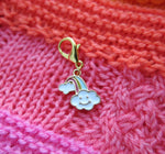 enamel charm with a smiling cloud and rainbow on a hanging lobster clasp