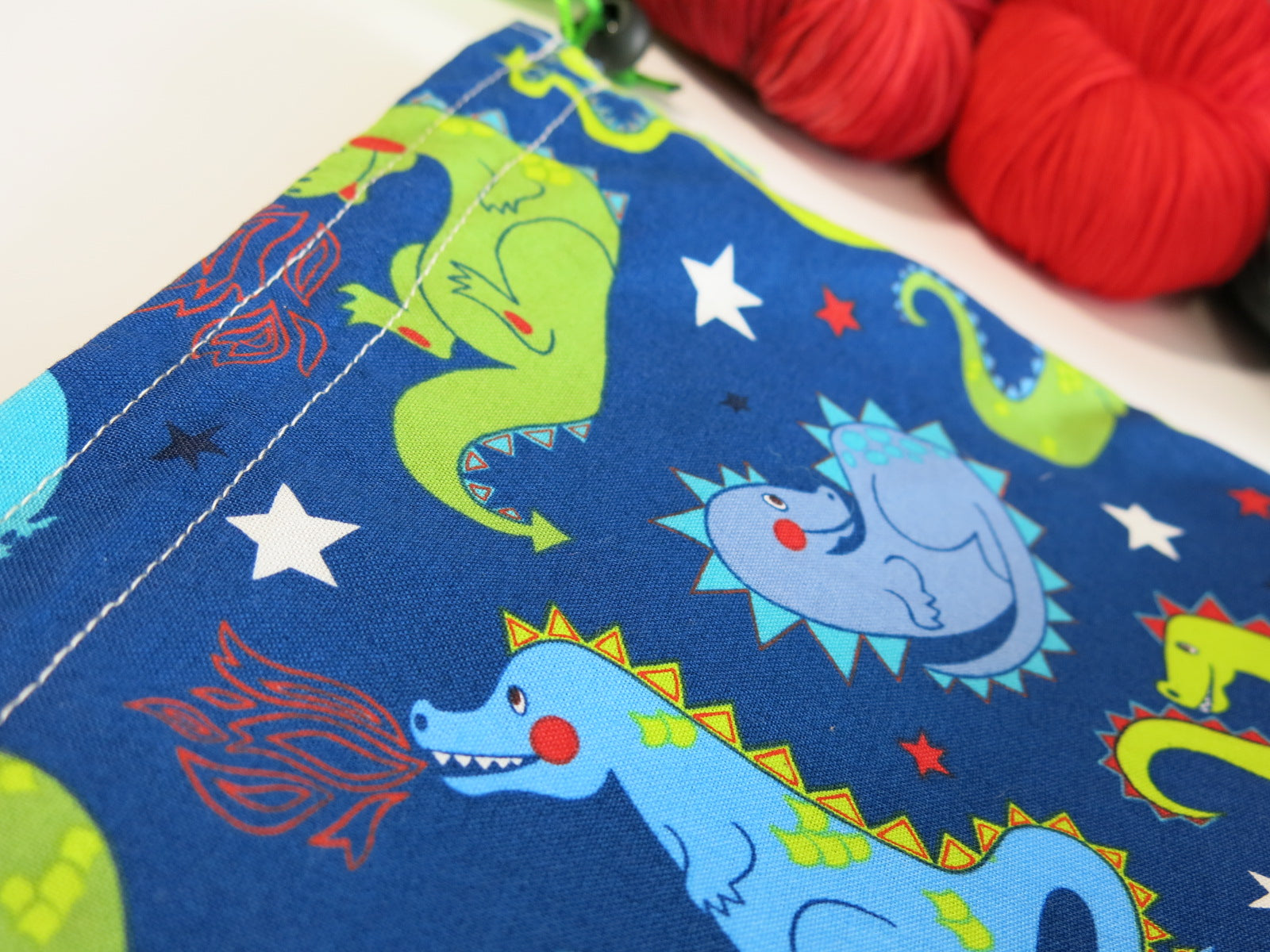 blue cotton knitting project bag with green and blue cartoon dragons