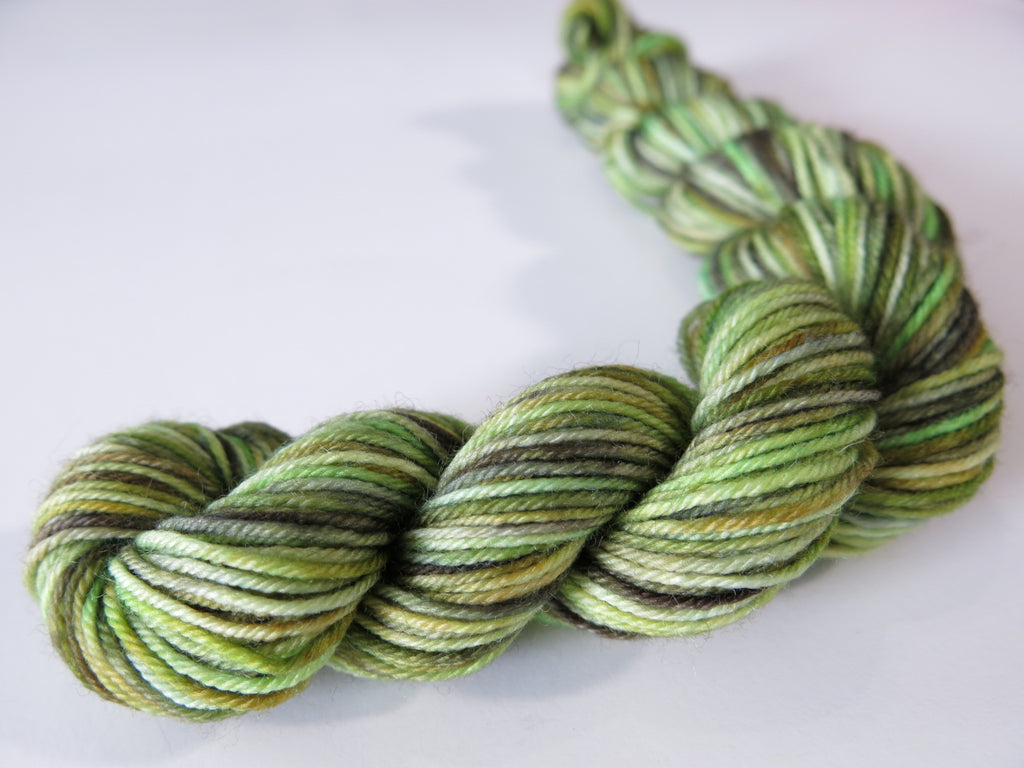 hand dyed sock yarn mini skein with multiple bright to mossy greens