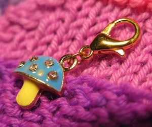 blue and yellow enamel mushroom stitch marker with rhinestones on a lobster clasp