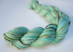 20g sock yarn mini skein in light turquoise with black and golden speckles