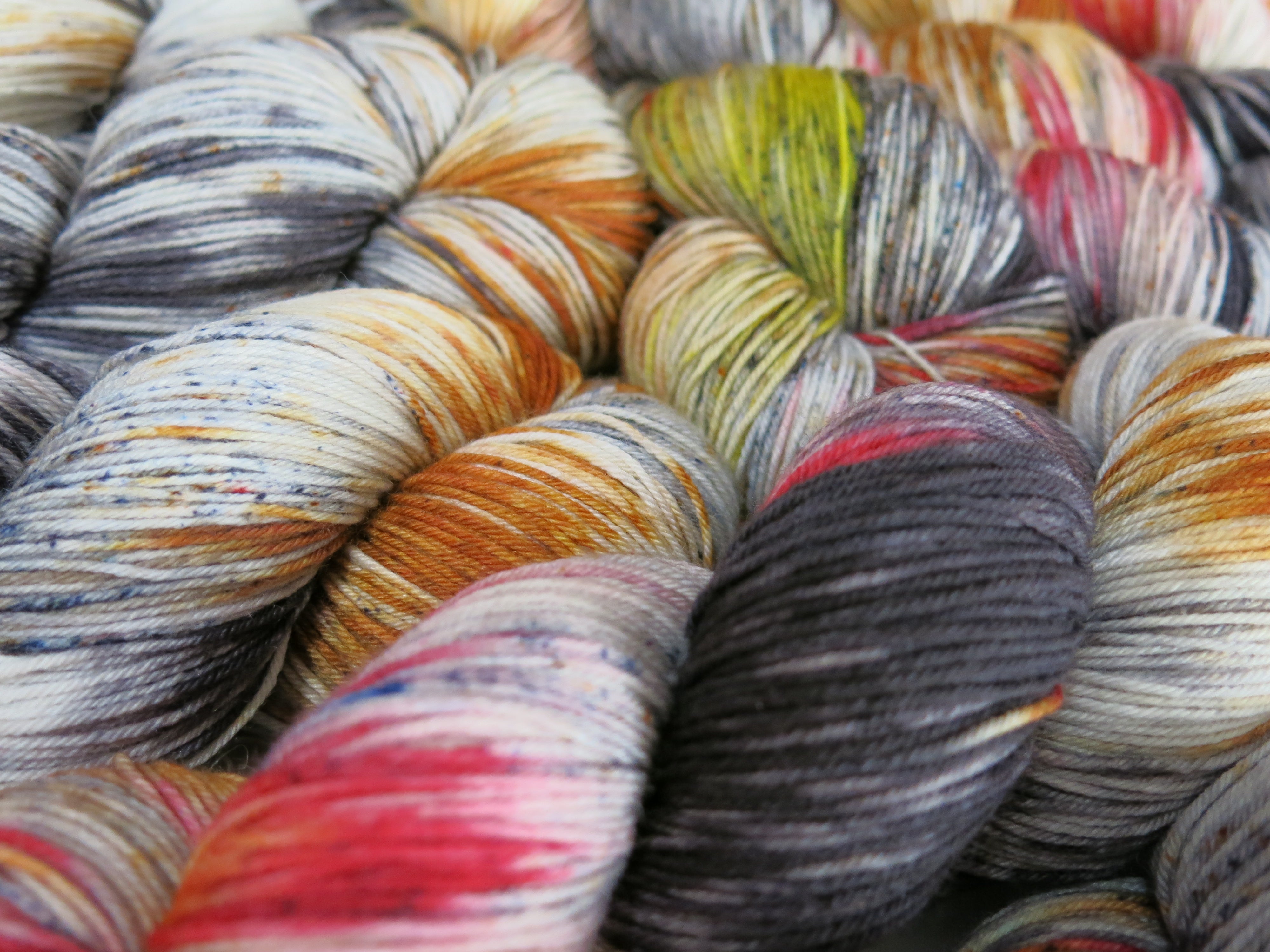 hand dyed yarn with black speckles and fire reds and yellows