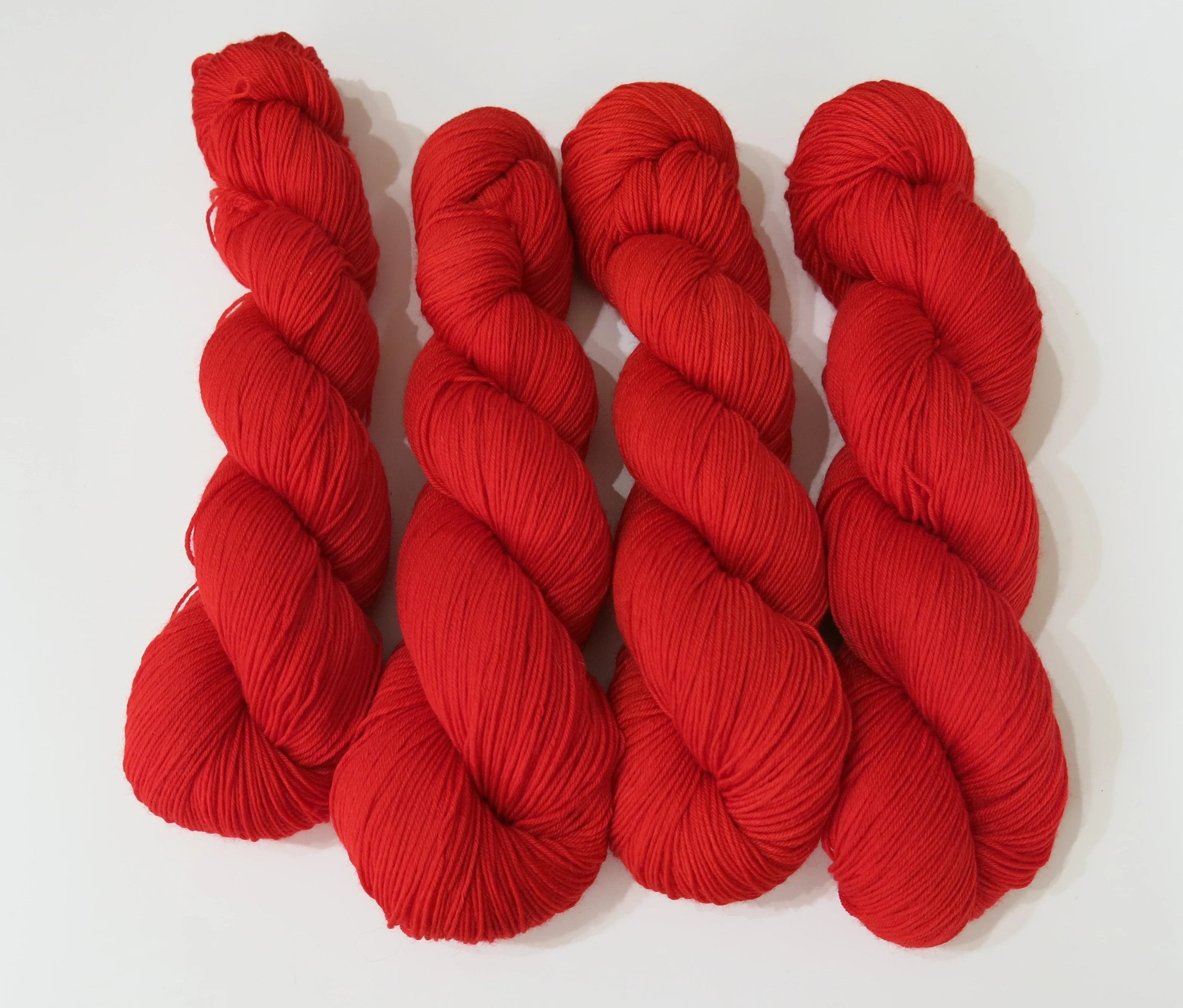 hand dyed solid red superwash merino sock yarn skeins