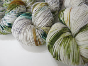 well of youth handdyed by my mama knits light grey yarn with green speckles