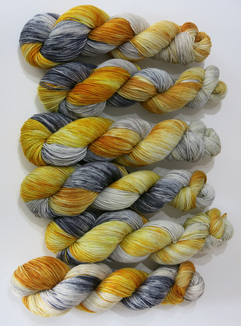 indie dyed superwash sock yarn skeins in golds and greys