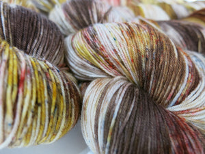indie dyed grey and brown sock yarn skeins with brown and red speckles