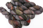 grey and black yarn skein with areas of dark and yellow orange