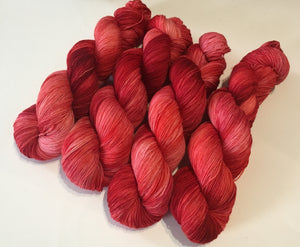 100g skeins red superwash merino sock yarn by my mama knits