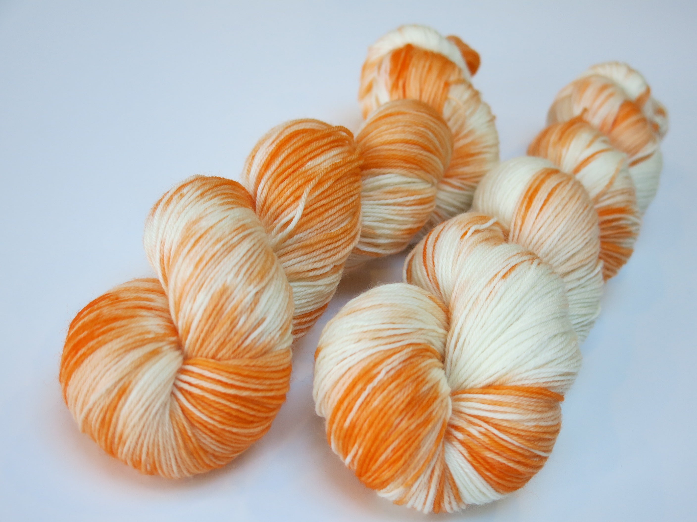 hand dyed orange and white superwash merino sock yarn